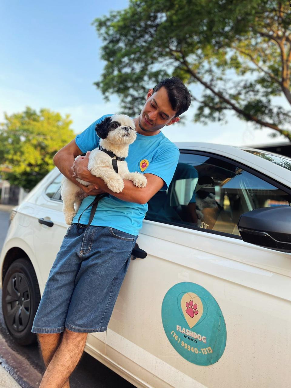 Flashdoguer com pet no colo ao lado do carro adesivado